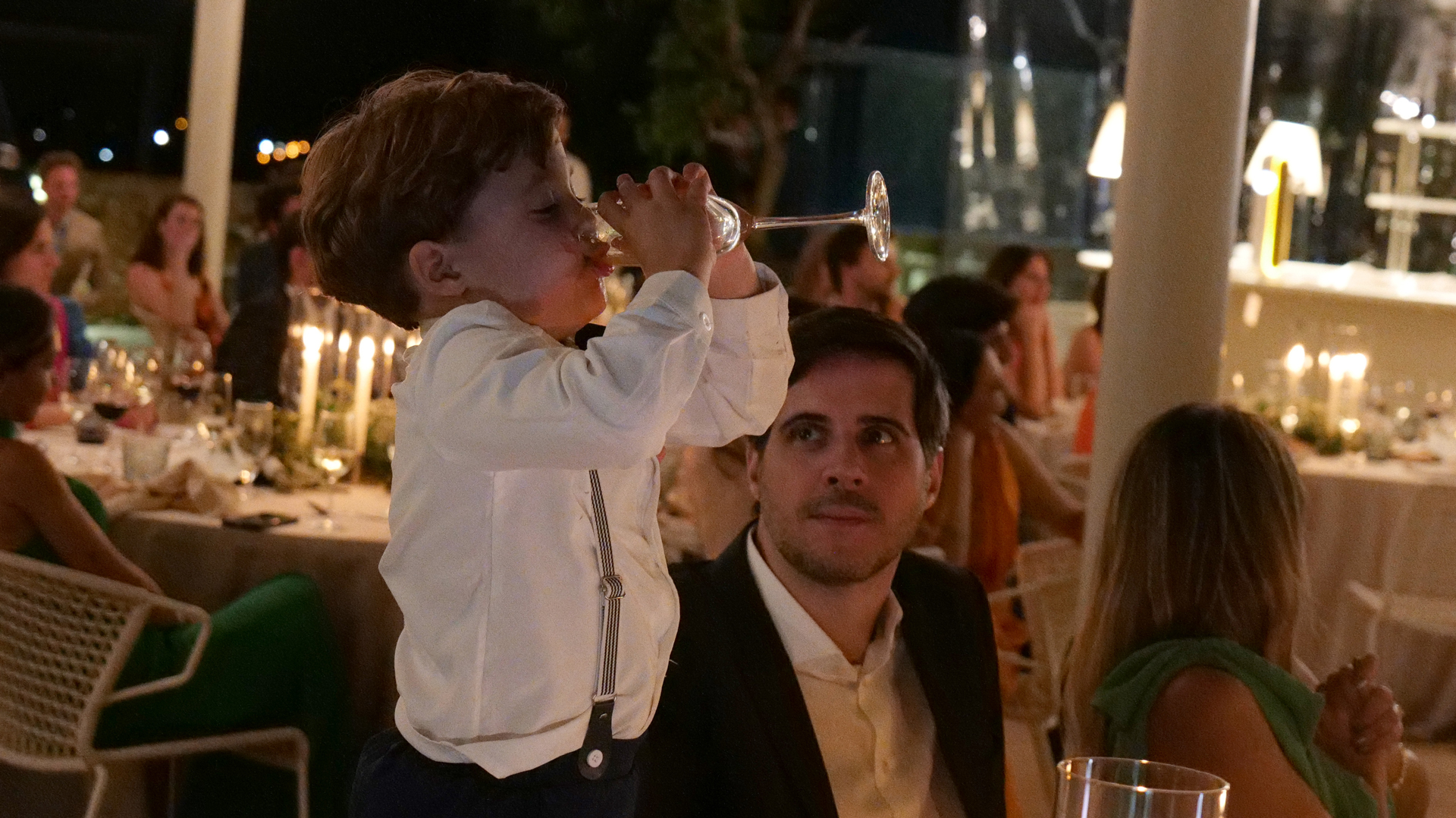 Niño bebiendo ante la mirada de su padre